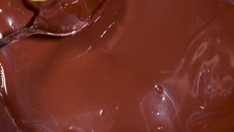 grapes being submerged in melted chocolate