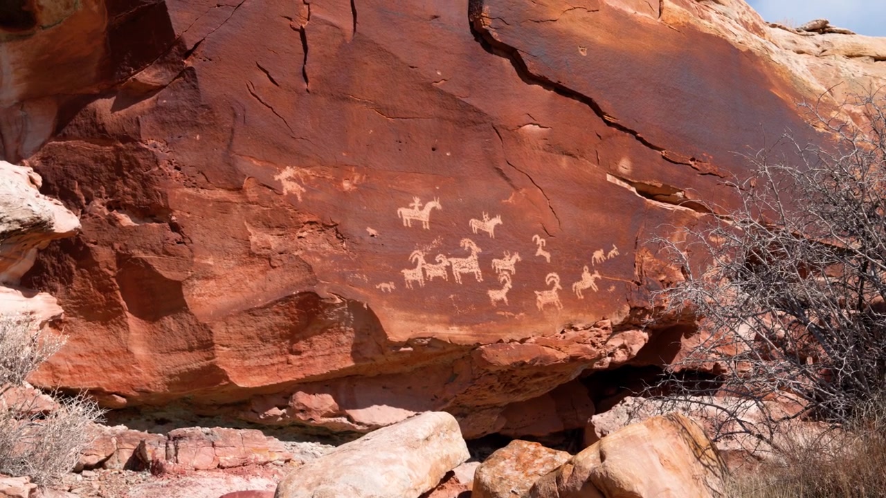 Incisioni rupestri di capre e altri animali selvatici sui massi di roccia rossa del Parco Nazionale degli Arches in una giornata di sole.