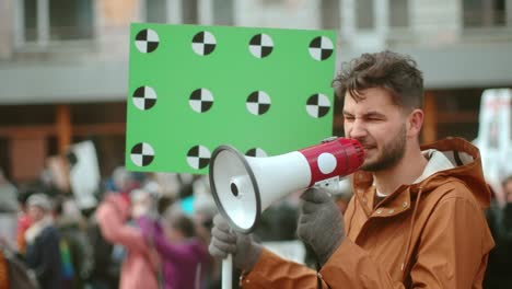 el hombre sostiene la pancarta en la mano. la gente grita puntos de seguimiento para el espacio de copia 4k.