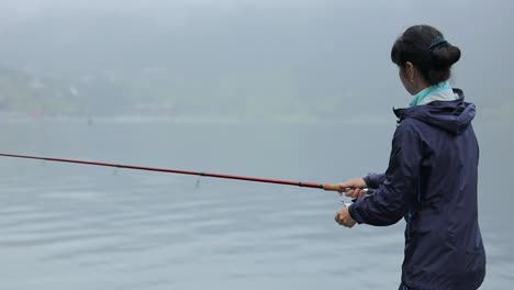 woman fishing on fishing rod spinning in norway.