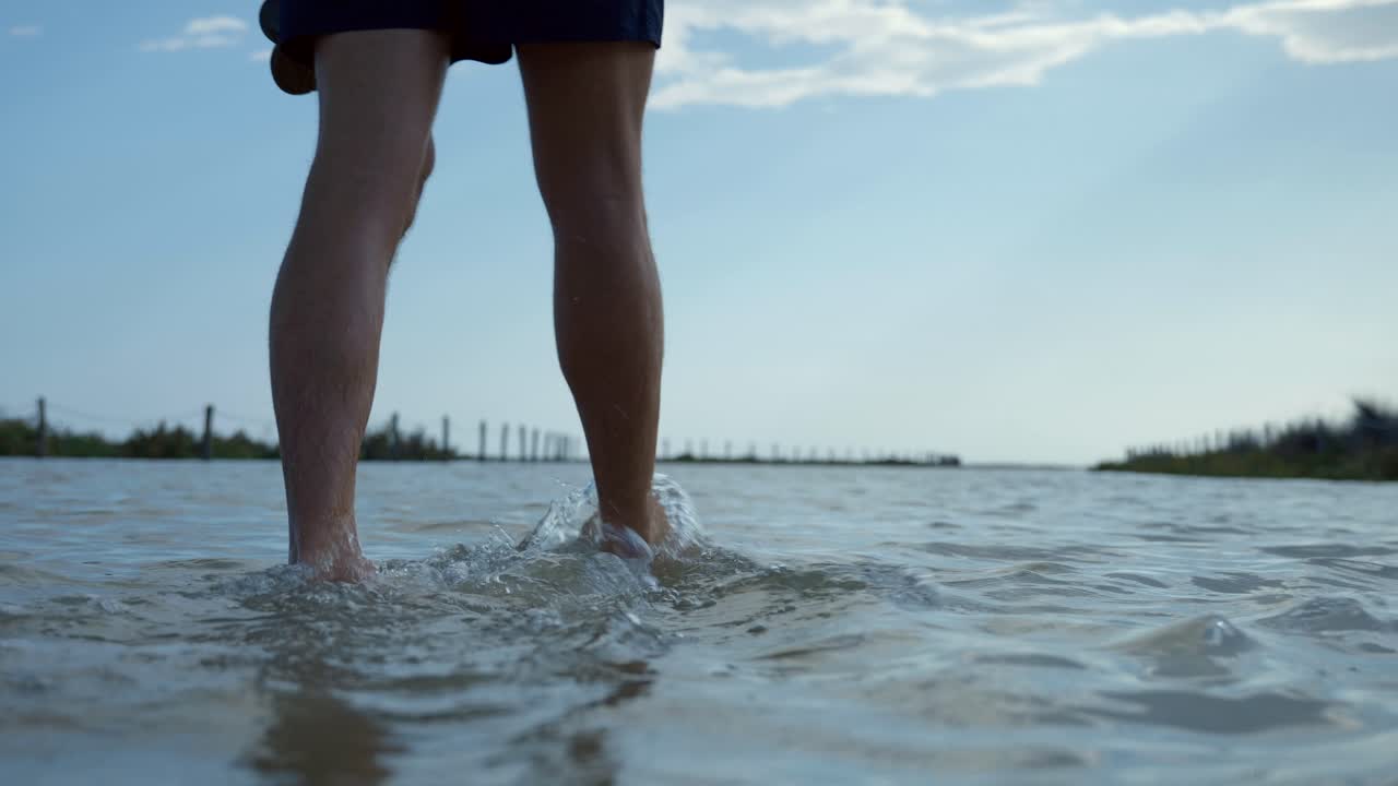 침수된 해변 지역을 걷고 있는 청년, 휴가 개념에 도착