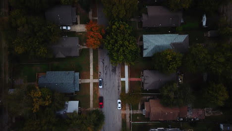 Aerial-top-down-over-countryside-huts-and-cottages-in-suburban-residential-area-with-cars-parked-on-lanes