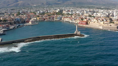 Olas-Rompiendo-En-El-Rompeolas-Del-Antiguo-Puerto-Veneciano-De-Chania-Con-Faro-En-Creta,-Grecia