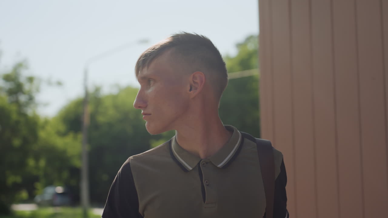 Young Man Observes, Youth Examines Bright Outdoor Scene, Anxious Youth Surveys Sunlit Urban Environment Carefully, Young Individual Scrutinizes Brightly Lit Street With Focus And Concern