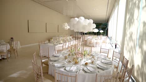 elegant white table decor for wedding or christening with balloons and tableware