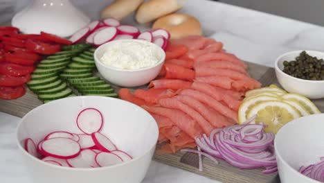 assembling bagel brunch board with smoked salmon