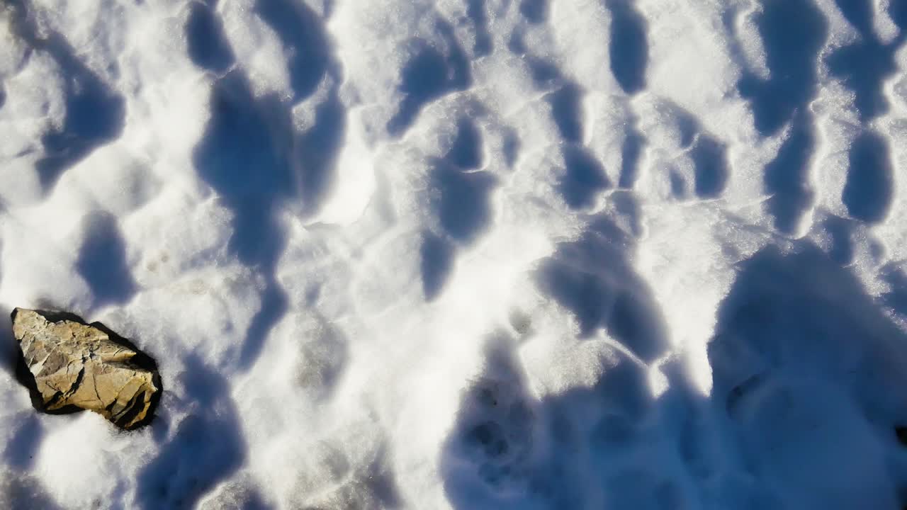 POV hiker's feet in boots walking in snow