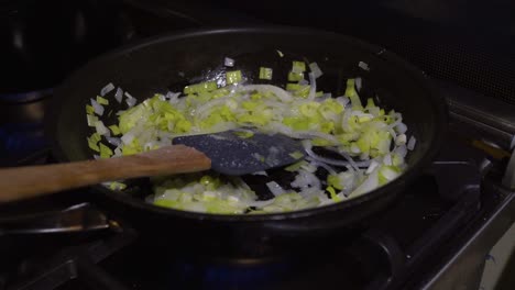 condimento de puerro y cebolla en sartén con espátula de descanso, cocina interior