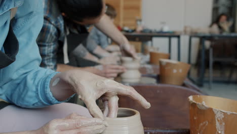 people working with clay in a pottery workshop