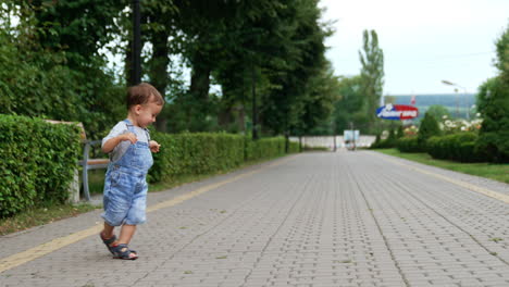 happy caucasian kid running circles in the park. healthy active child having fun outdoors in summer.