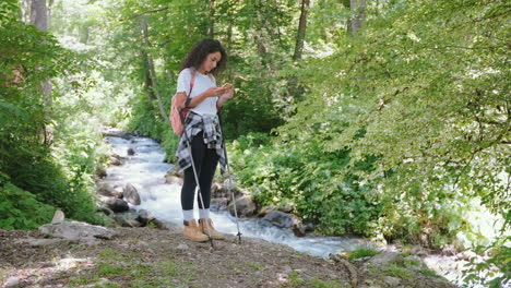 woman hiking in a forest by a stream