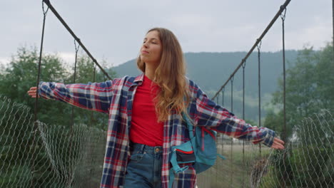 hitchhiker walking river bridge in mountains nature. free girl enjoy traveling.