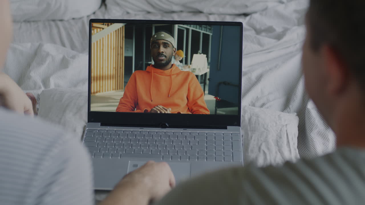 Two Men Having a Video Call in Bed
