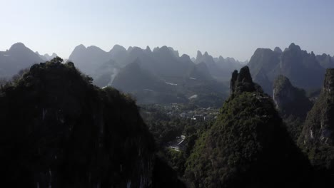 Amplia-Toma-Aérea-De-Un-Pueblo-Aislado-Rodeado-De-Montañas-En-Yangshuo,-China