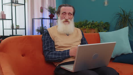 Senior-old-man-looking-at-laptop,-making-video-webcam-conference-call-with-friends-or-family-at-home
