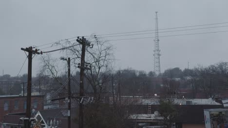 una toma amplia de un día lluvioso con vista a una ciudad somnolienta y obrera con una alta torre de telefonía celular al fondo