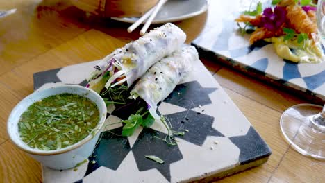 closeup of fresh vietnamese rice paper rolls on plate next to dipping sauce