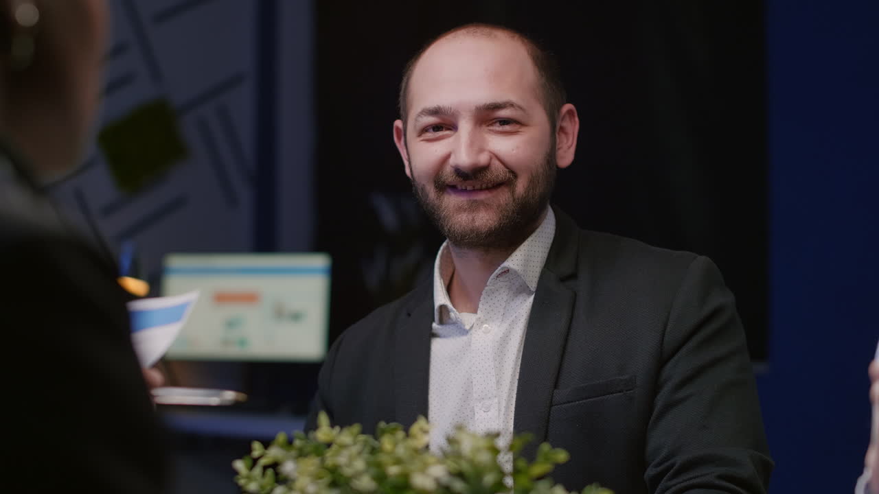 Portrait of focused manager looking into camera sitting at conference table in meeting office