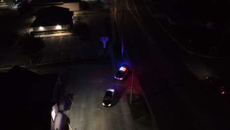 police car stopping black car on american highway. aerial top down shot. flashing blue and red lights of police vehicle.