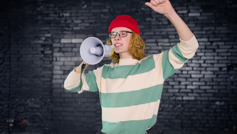 young caucasian environmental activist protesting with megaphone indoors