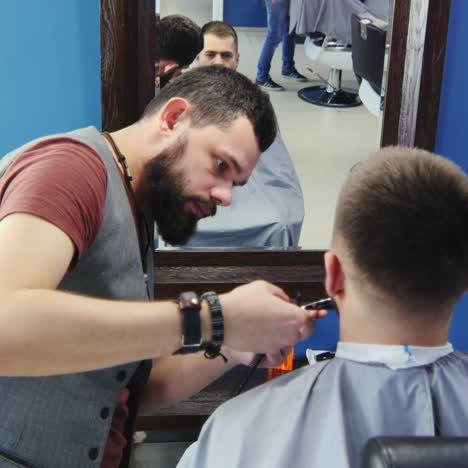 peluquero recortando barba para cliente usando tijeras