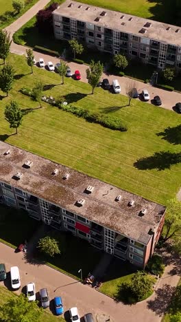 Aerial View of Residential Apartment Buildings with Green Spaces and Parked Cars