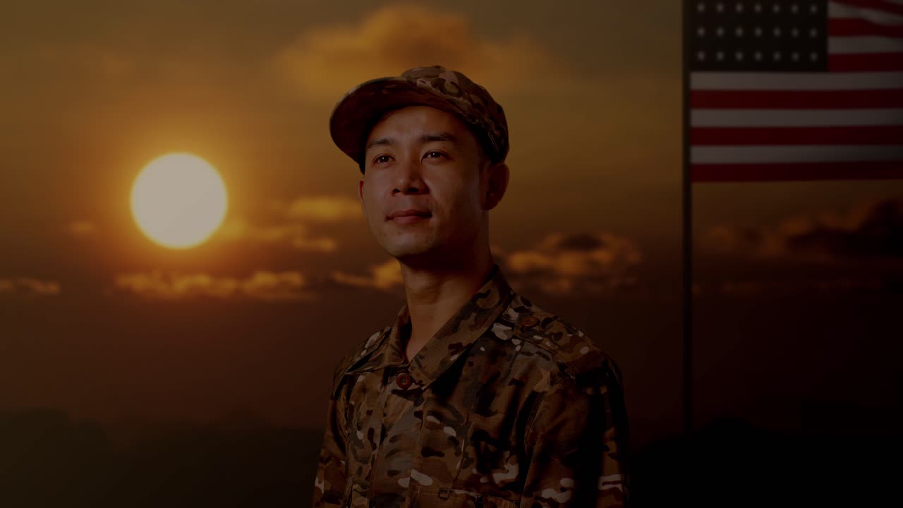 으로 가까이 쳐다보는 아시아 남성 군인이 미국 발을 들고 서서 주위를 둘러보고 있다.