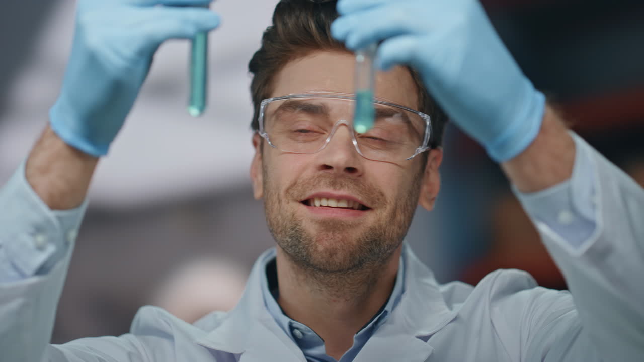trabajador de laboratorio mirando tubos de ensayo satisfechos resultados de la investigación en el laboratorio de cerca