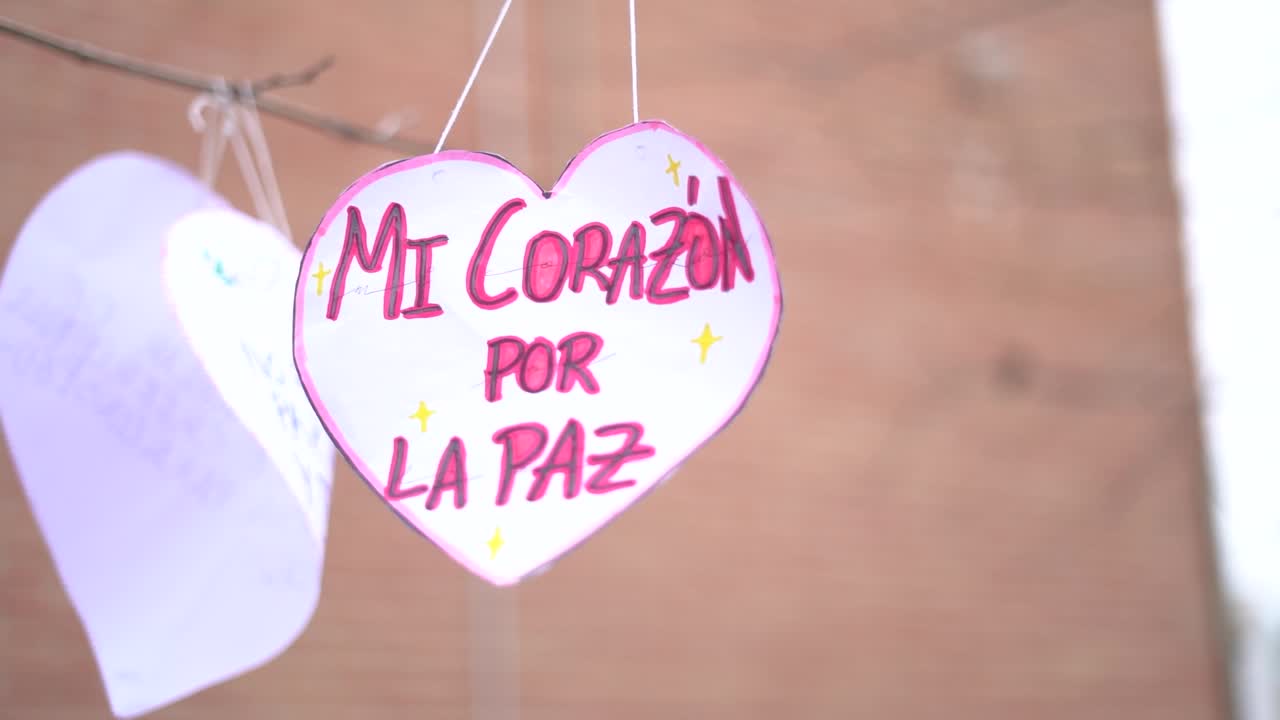 los niños de la educación primaria crean corazones con la frase "mi oír para la paz