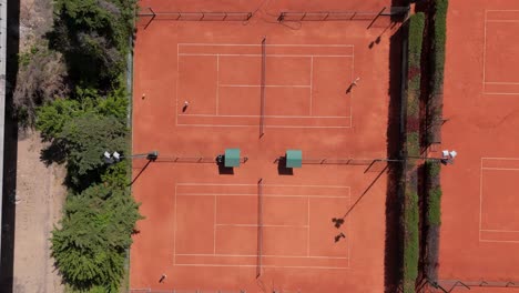 aerial view of four tennis courts with players