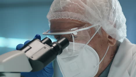 Senior-Scientist-in-Mask-Using-Microscope-in-Lab