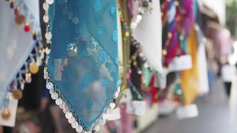 close-up of blue scarves with coin embellishments at a market stall