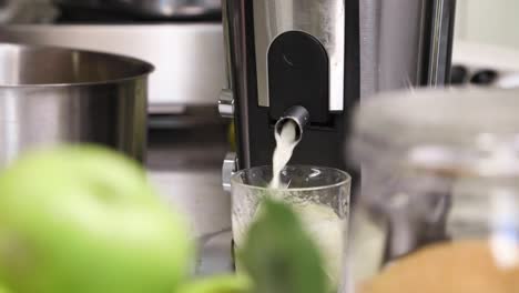 juice extractor extracting juicy apples in the kitchen - close up, slow motion