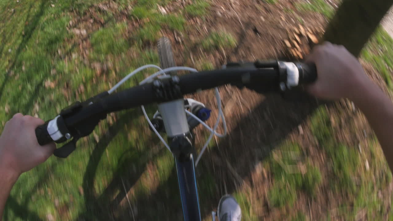punto de vista de un hombre montando una bicicleta en un parque