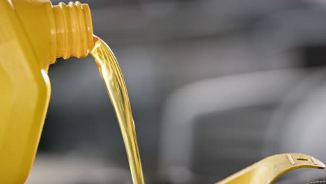 slow-motion close-up of golden motor oil being poured into an engine.
