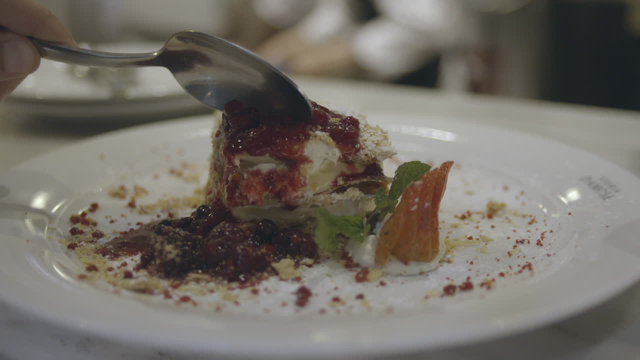 la persona se entrega a un delicioso postre gourmet adornado con frutas rojas vibrantes, saboreando cada bocado celestial, y saboreando la armoniosa mezcla de sabores y texturas que bailan en su paladar