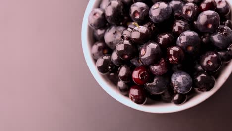 movimiento lento de arándanos frescos en un cuenco blanco. espacio para el texto. el concepto de desayuno saludable.