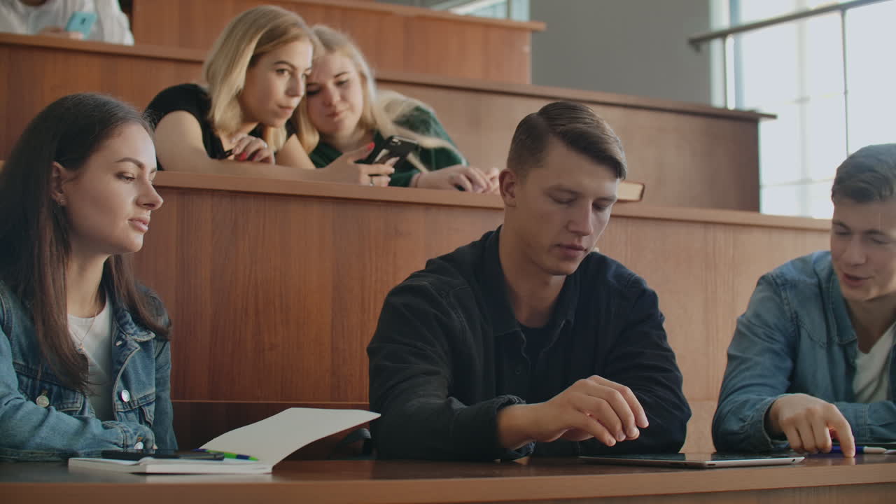 수업 전에 강의실에 앉아있는 기쁜 학생들의 그룹.