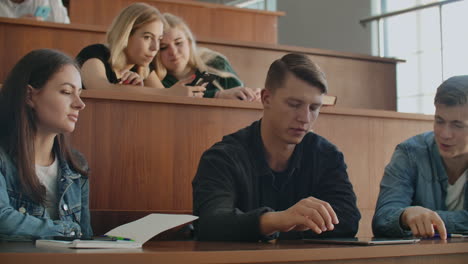 the group of cheerful happy students sitting in a lecture hall before lesson. the group of cheerful students sitting in a lecture hall before lesson.