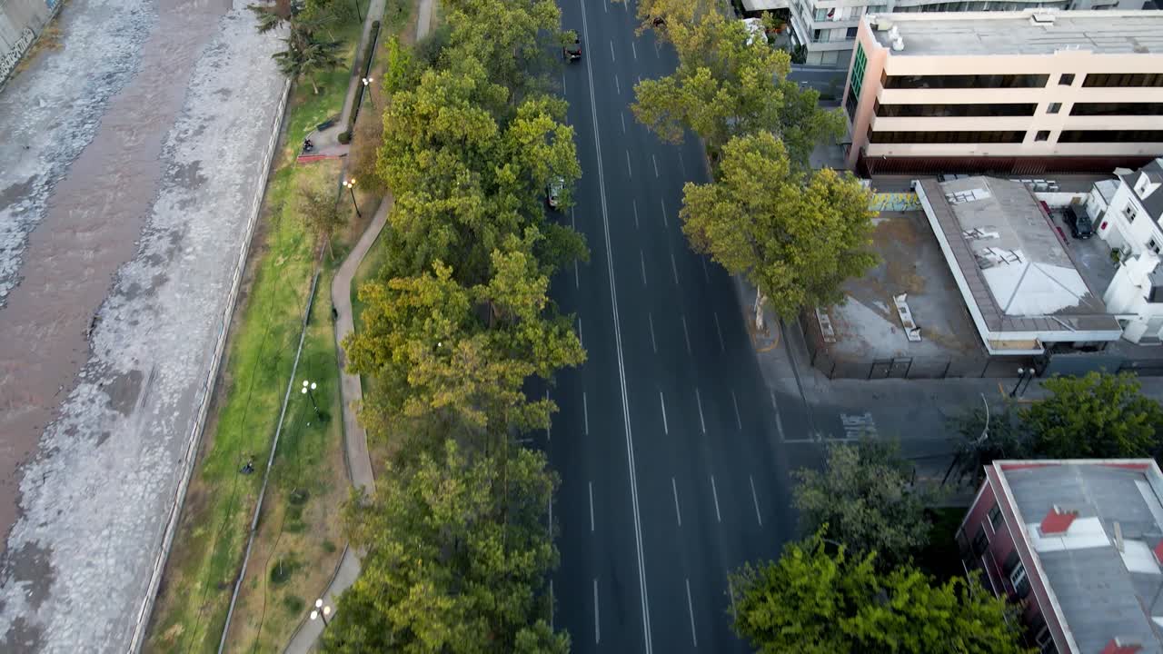 낮에는 나무와 건물로 둘러싸인 넓은 거리에서 운전하는 자동차의 공중 도리