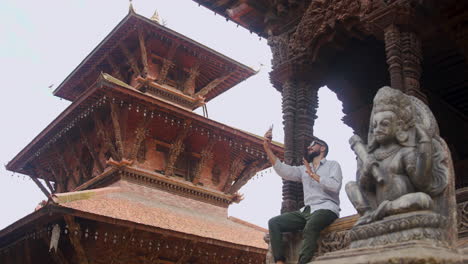 un hombre que muestra la famosa plaza de patan durbar, patrimonio de nepal en una videollamada, sentado y apreciando la belleza arquitectónica