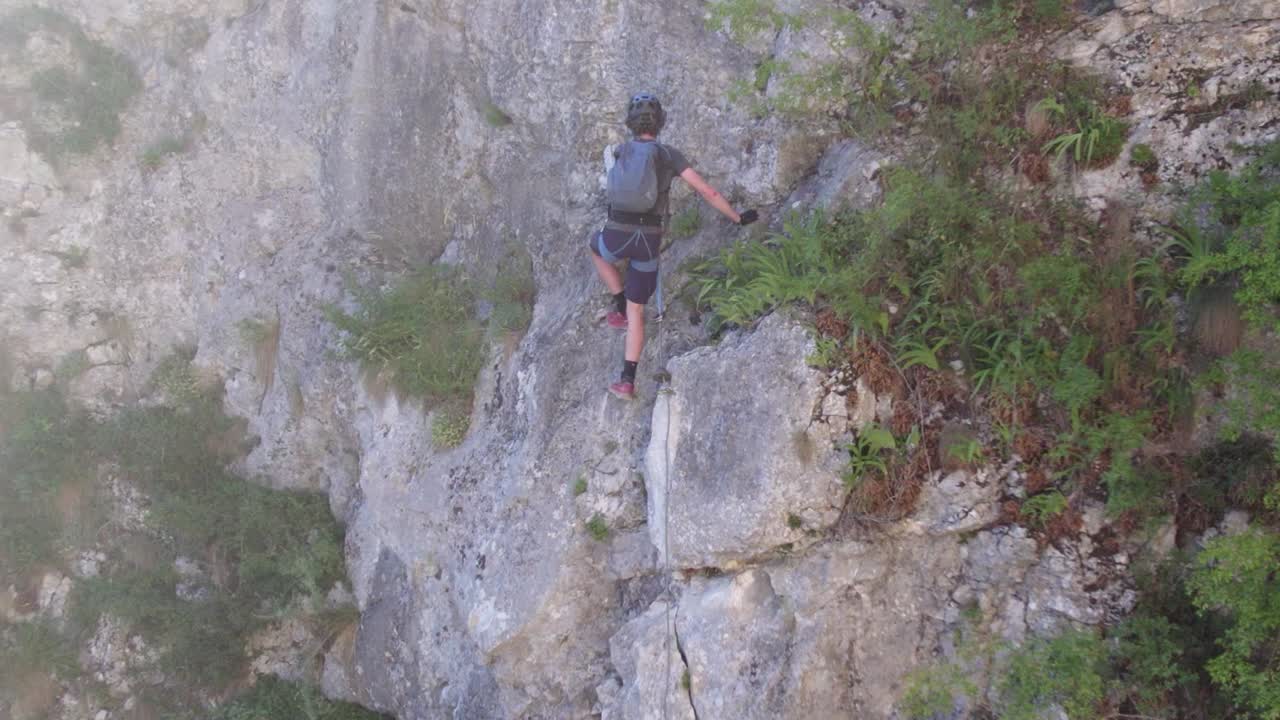 primer plano de un turista escalando una ruta de ferrata en una montaña cárstica