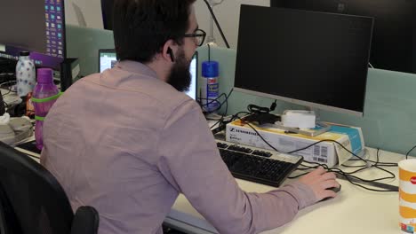 en la oficina, un hombre positivo multitarea, trabajando diligentemente en su computadora portátil mientras participa en una reunión productiva, mostrando su enfoque eficiente y centrado