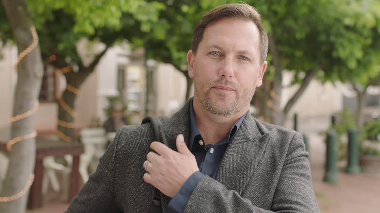 성공적인 도시 생활 방식을 즐기는 카메라에 자신감 있게 진지하게 보이는 백인 사업가의 초상화 남성 통근자 코트를 입고