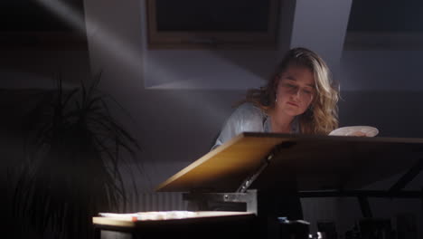 woman artist drawing at a table in a home studio