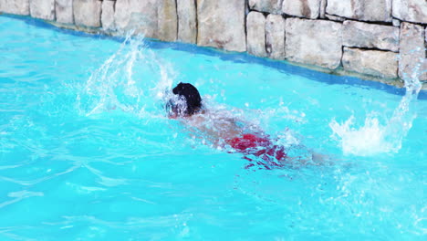 niño nadando con un traje de baño rojo