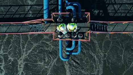 top view of two workers at the wastewater treatment site