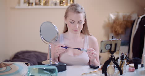 woman doing makeup painting eyelashes with mascara 8