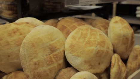 man putting bread bun on a pile