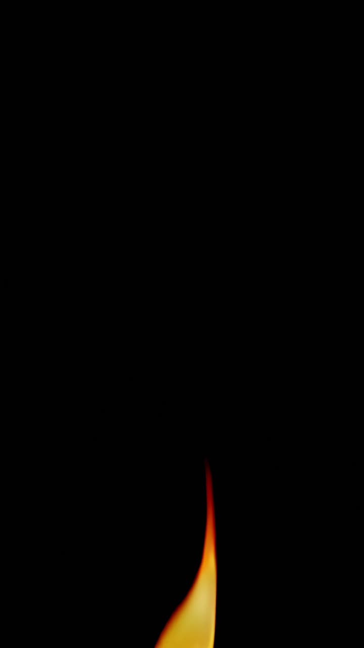 Close-up video frame of a small flame against a black background, captured from a low angle
